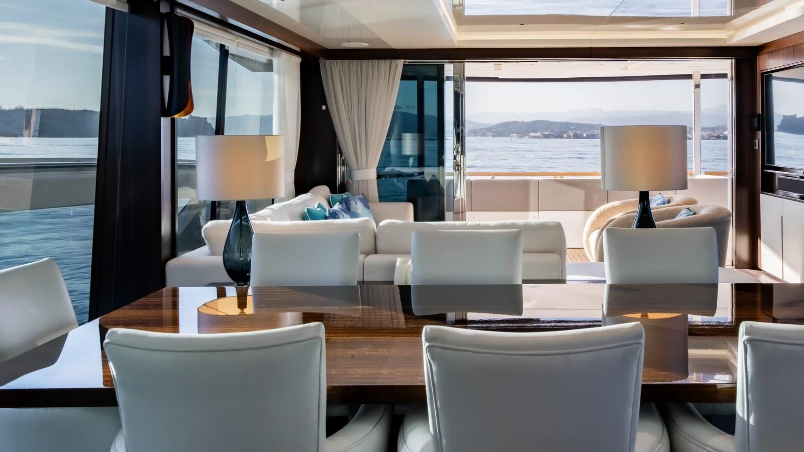 The yacht's salon features a luxurious seating area with elegant furnishings and panoramic windows offering stunning views. aboard TRIPLE EIGHT Yacht for Sale