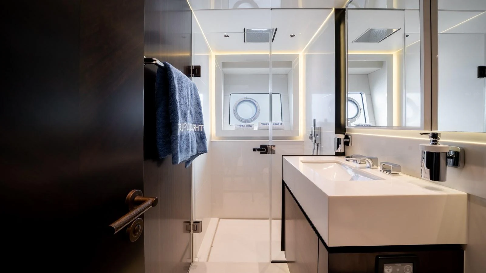 A sleek and modern yacht bathroom with a large mirror and contemporary fixtures. aboard TRIPLE EIGHT Yacht for Sale