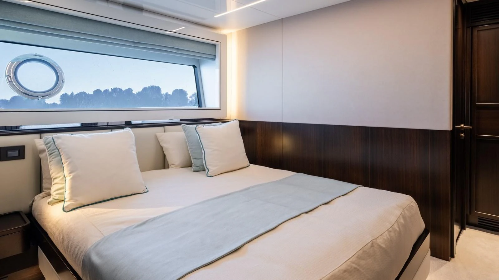 The stateroom features a large bed with plush pillows and a scenic window view. aboard TRIPLE EIGHT Yacht for Sale