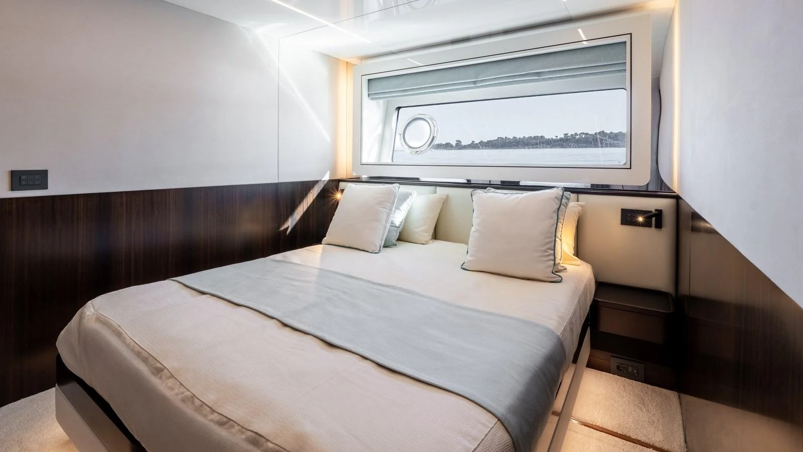 A luxurious stateroom featuring a large bed with plush pillows and a scenic window view. aboard TRIPLE EIGHT Yacht for Sale