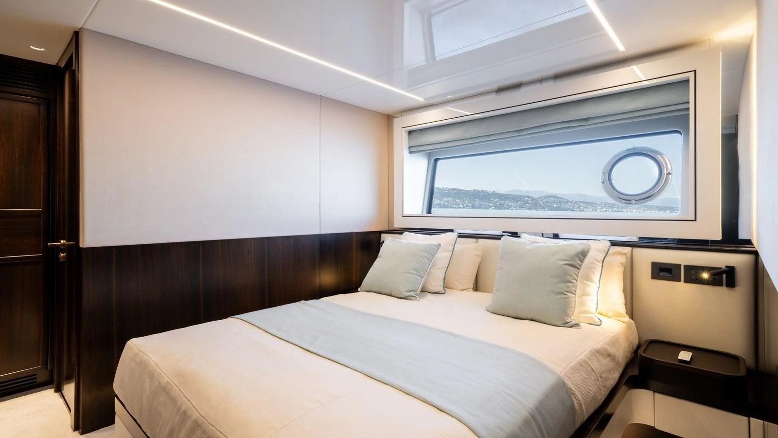 A luxurious stateroom featuring a large bed with plush pillows and a scenic window view. aboard TRIPLE EIGHT Yacht for Sale