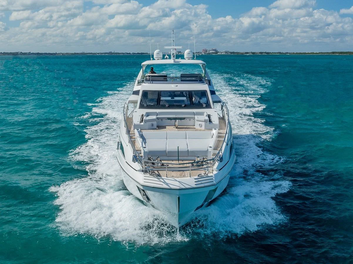 A luxurious yacht cruising through clear blue waters under a partly cloudy sky. aboard PIER PRESSURE Yacht for Sale
