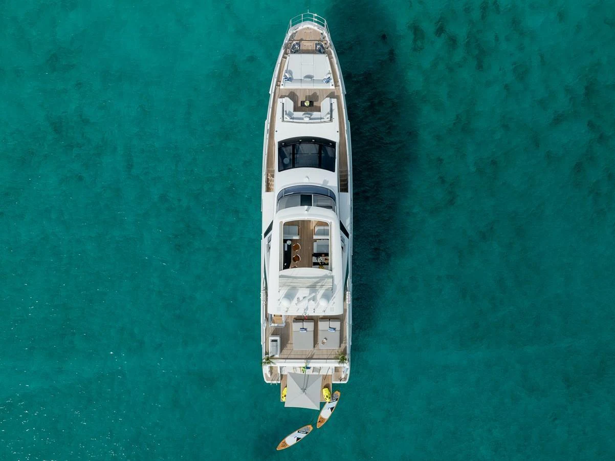 A stunning overhead view of a luxury yacht anchored in clear turquoise waters, showcasing its spacious decks and water toys. aboard PIER PRESSURE Yacht for Sale