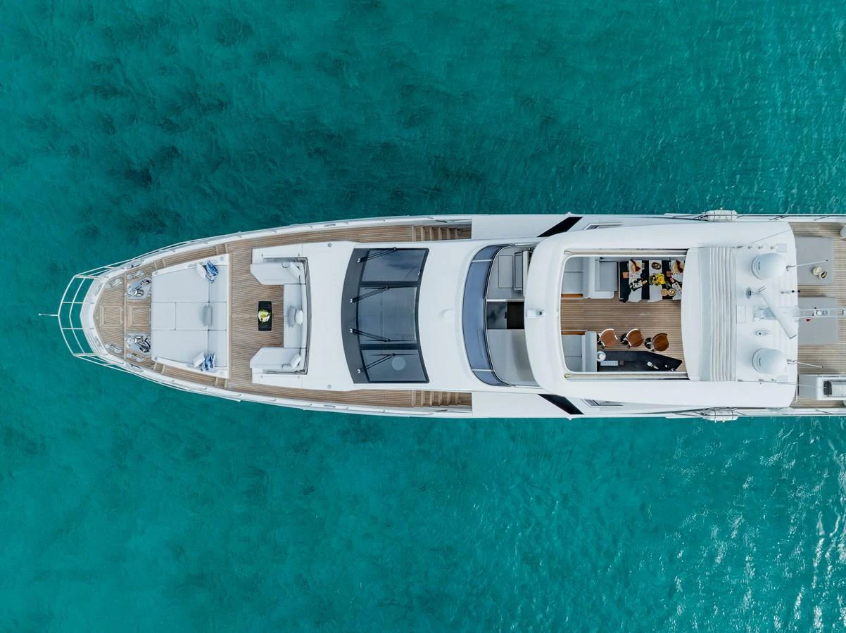 An aerial view of a sleek yacht cruising through clear turquoise waters. aboard PIER PRESSURE Yacht for Sale