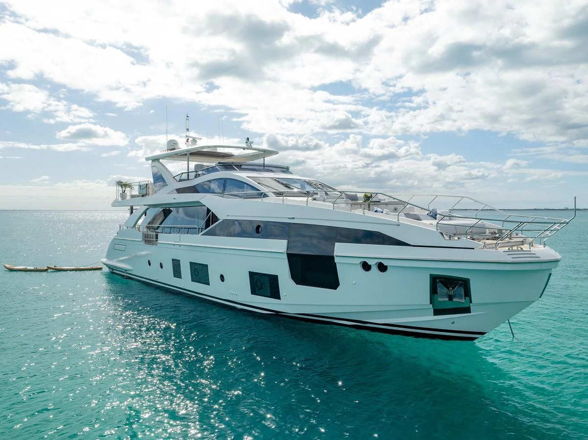 A sleek and modern yacht glides gracefully on clear turquoise waters under a partly cloudy sky. aboard PIER PRESSURE Yacht for Sale
