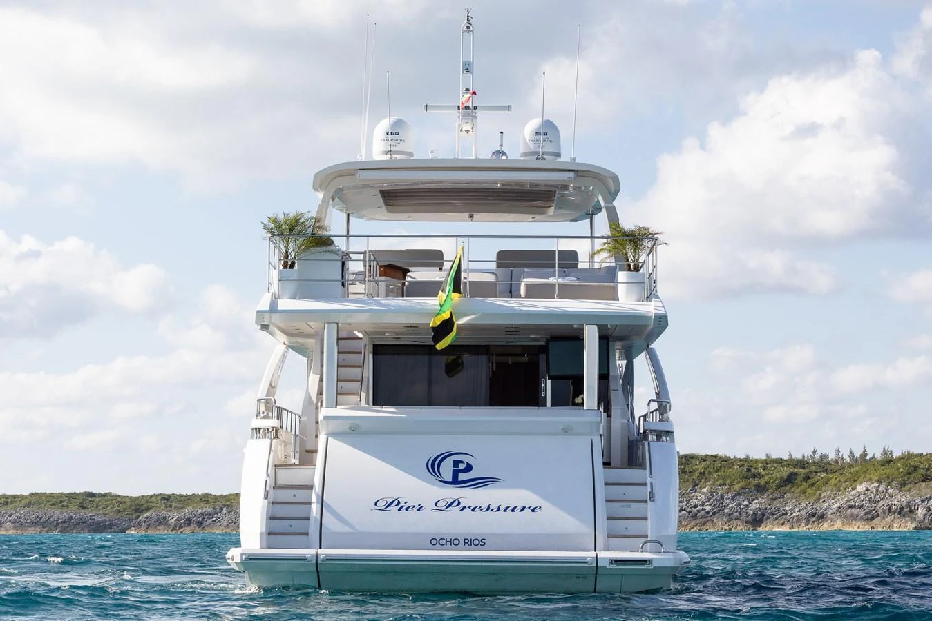 The yacht is seen from the rear, showcasing its elegant design and spacious deck. aboard PIER PRESSURE Yacht for Sale