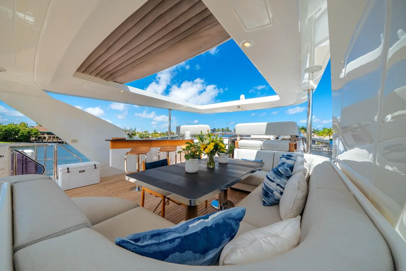 The flybridge offers a spacious and luxurious outdoor seating area with a dining table and stunning views. aboard PIER PRESSURE Yacht for Sale
