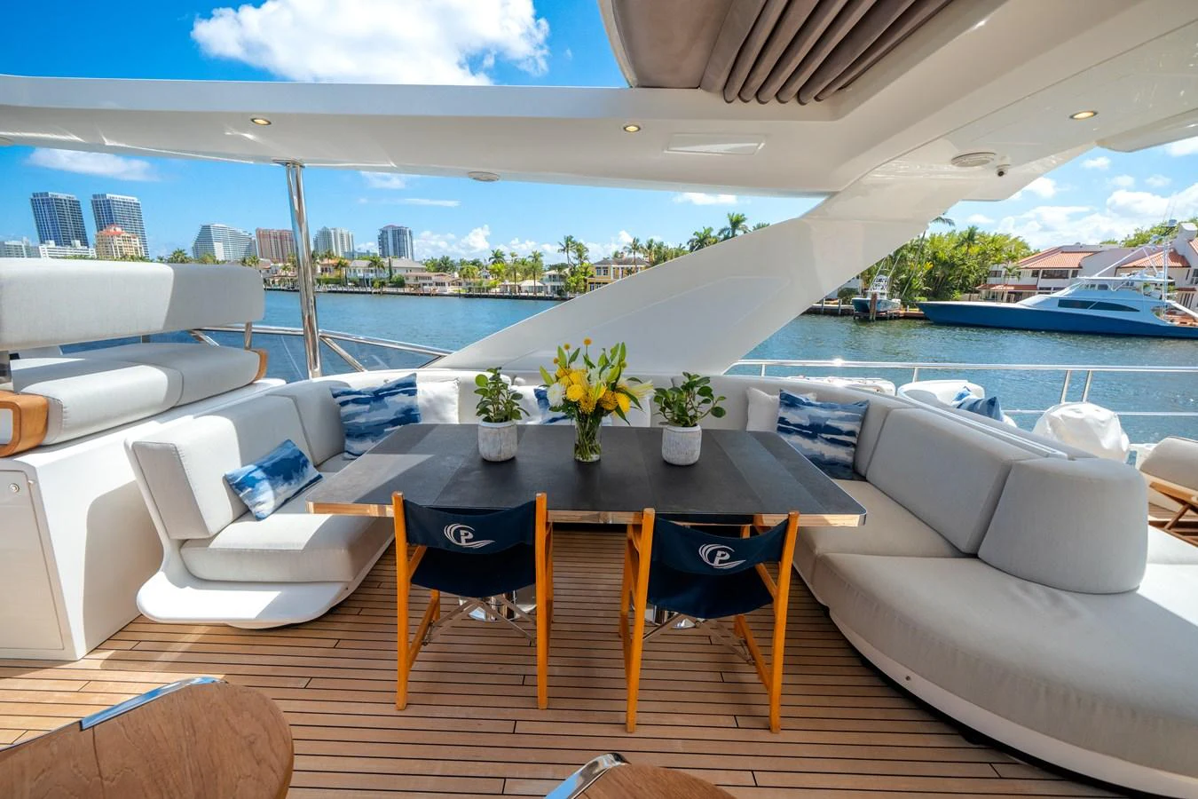 The aft deck features a stylish dining area with comfortable seating and a beautiful waterfront view. aboard PIER PRESSURE Yacht for Sale