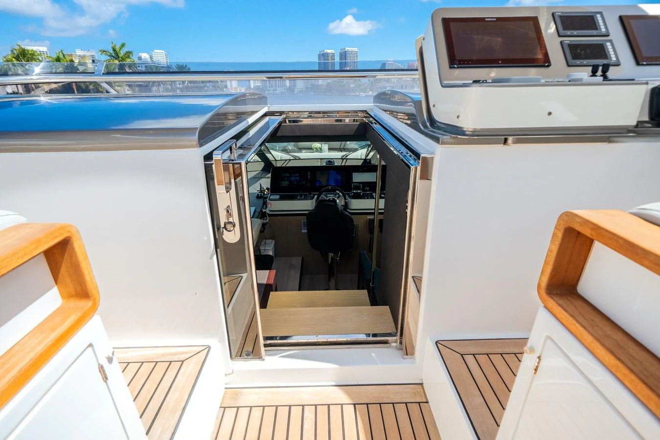 The image showcases the helm station of a yacht, viewed from the exterior with a glimpse into the control area. aboard PIER PRESSURE Yacht for Sale