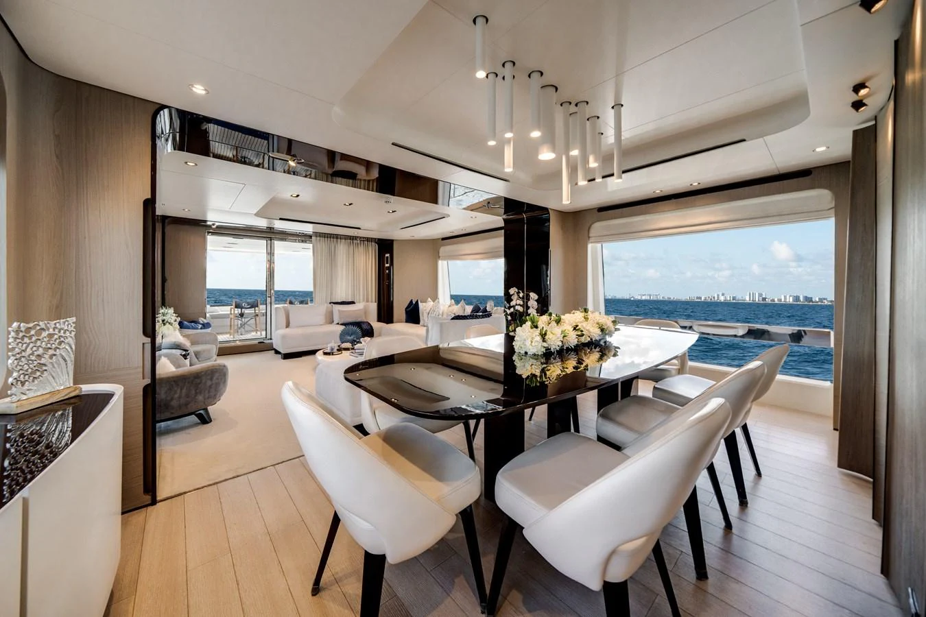 The yacht's dining area features a sleek table with elegant seating and panoramic ocean views. aboard PIER PRESSURE Yacht for Sale