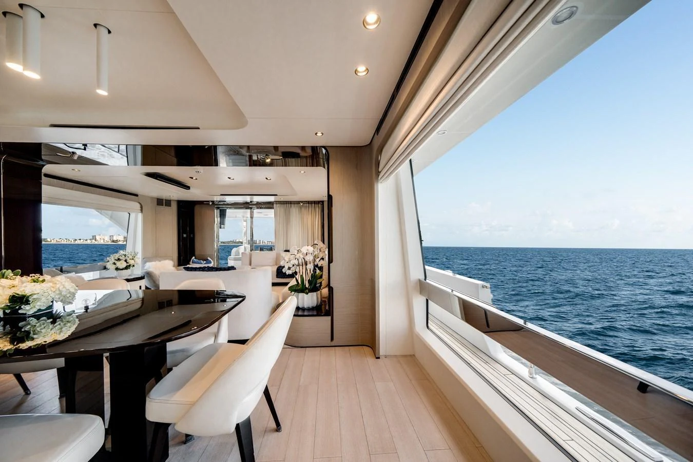 The yacht's dining area offers a luxurious space with expansive ocean views through large windows. aboard PIER PRESSURE Yacht for Sale