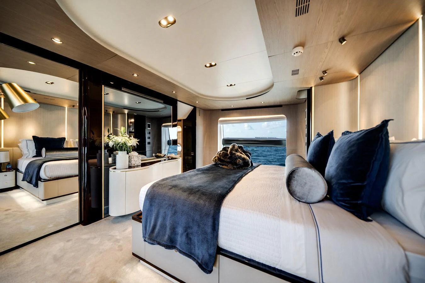 The master stateroom features a luxurious bed with plush bedding and elegant decor, offering a serene retreat with a view of the sea. aboard PIER PRESSURE Yacht for Sale