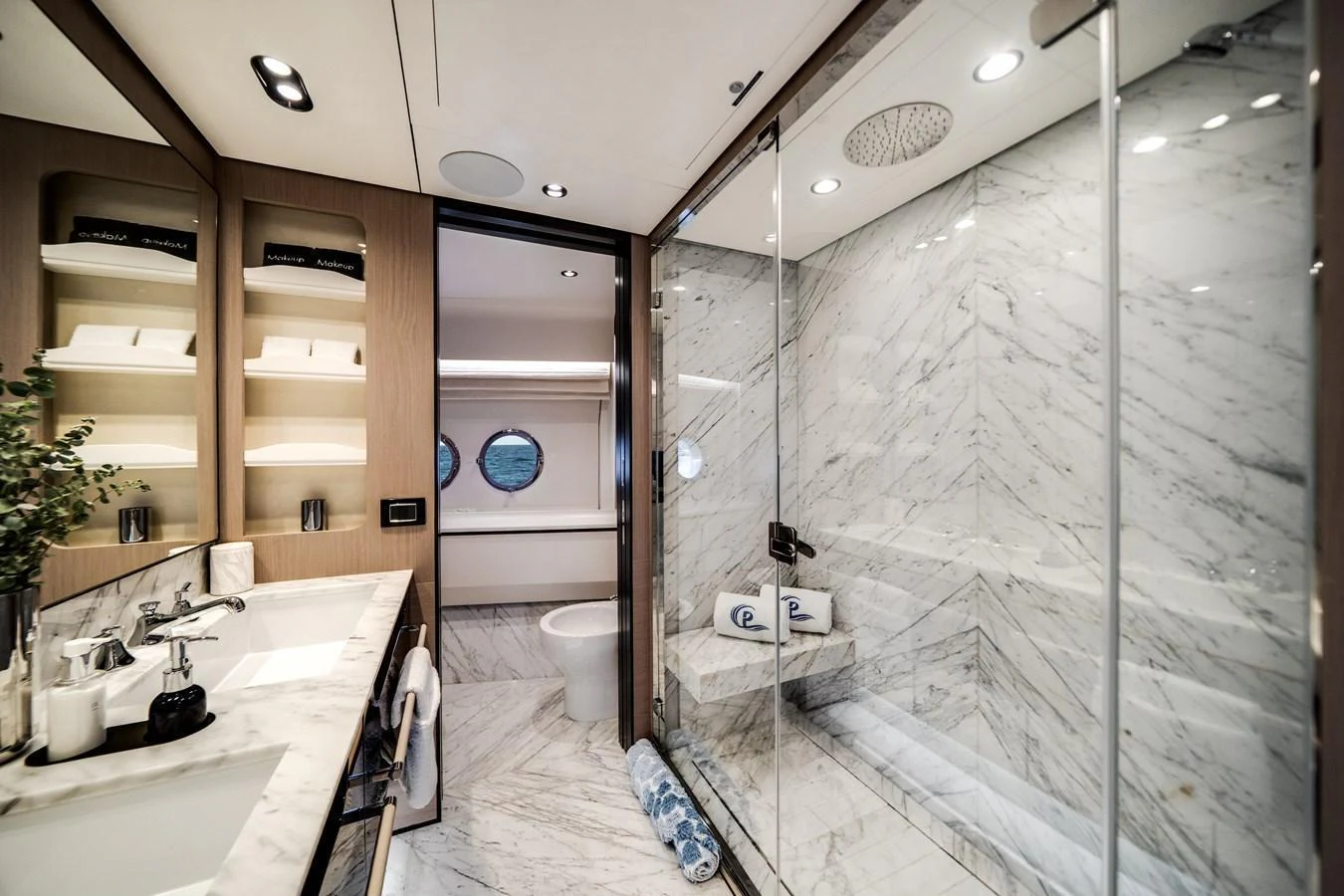 A luxurious yacht bathroom featuring a spacious glass-enclosed shower and elegant marble finishes. aboard PIER PRESSURE Yacht for Sale