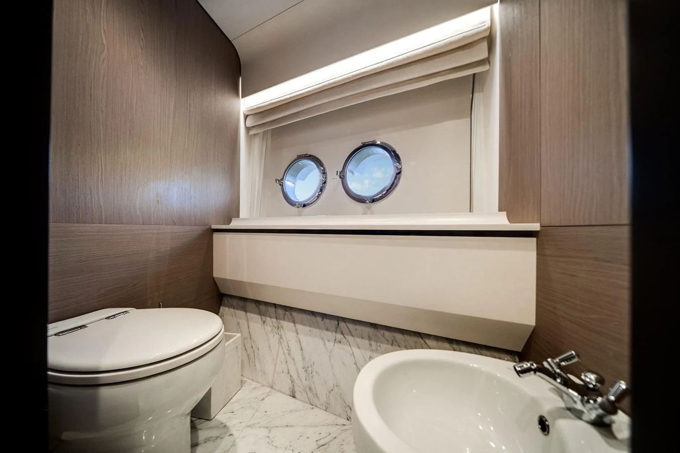The yacht's head features modern fixtures and a sleek design with natural light from portholes. aboard PIER PRESSURE Yacht for Sale