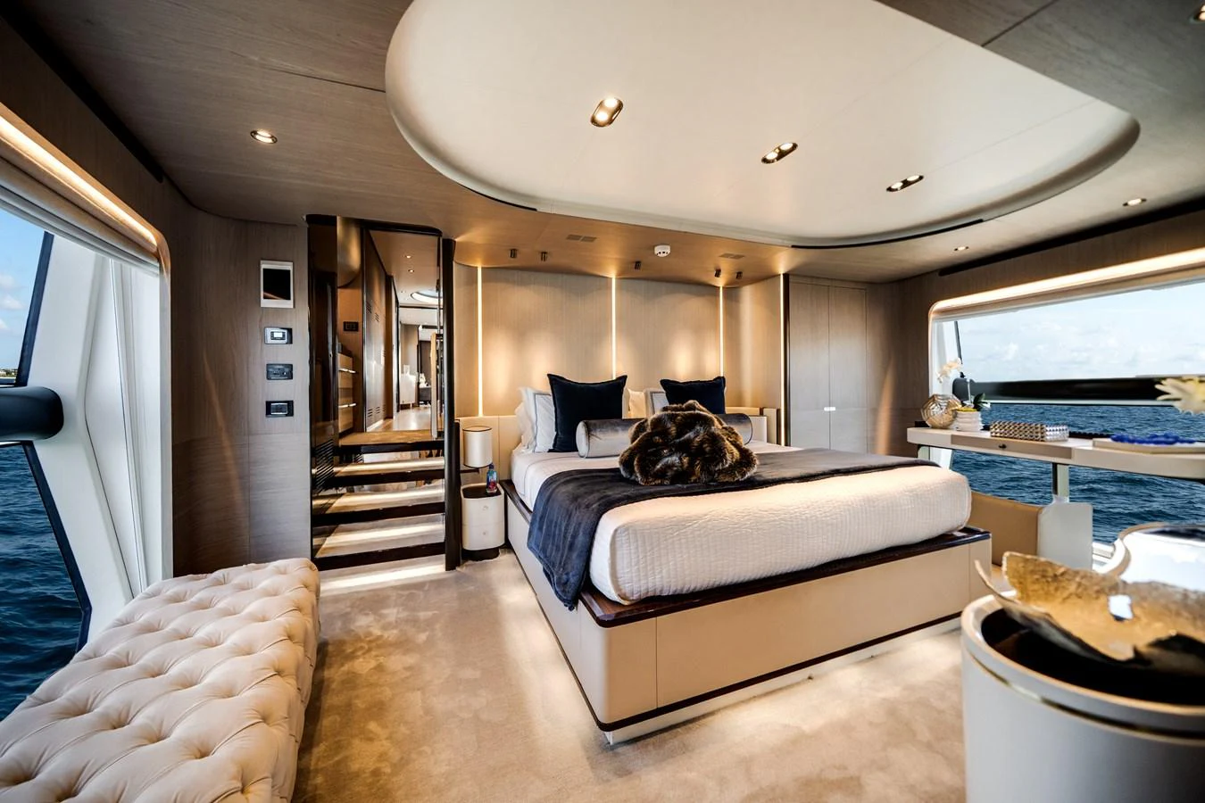 The master stateroom features a luxurious bed, elegant decor, and expansive windows with ocean views. aboard PIER PRESSURE Yacht for Sale