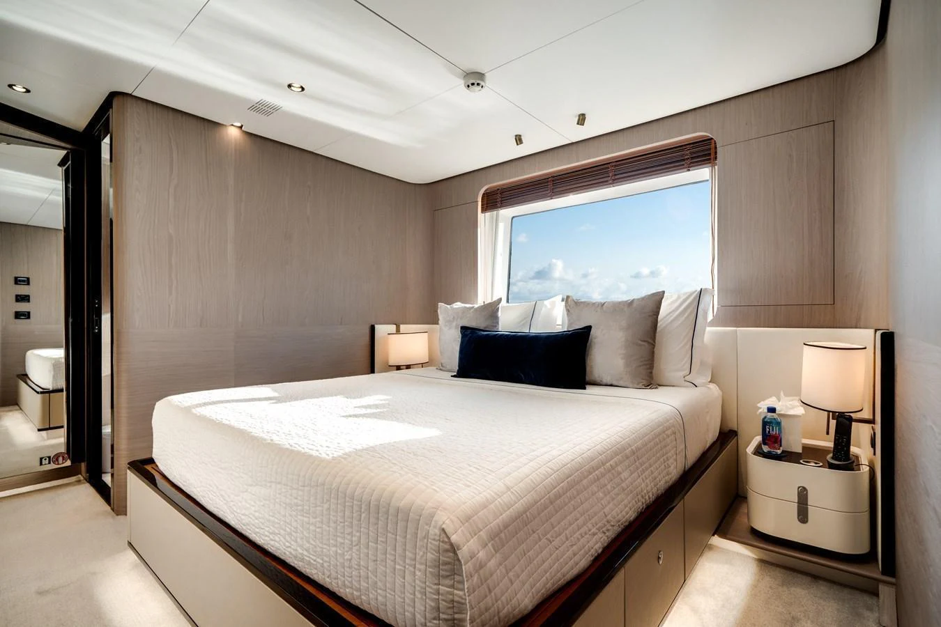A luxurious stateroom with a large bed and ample natural light from the window. aboard PIER PRESSURE Yacht for Sale