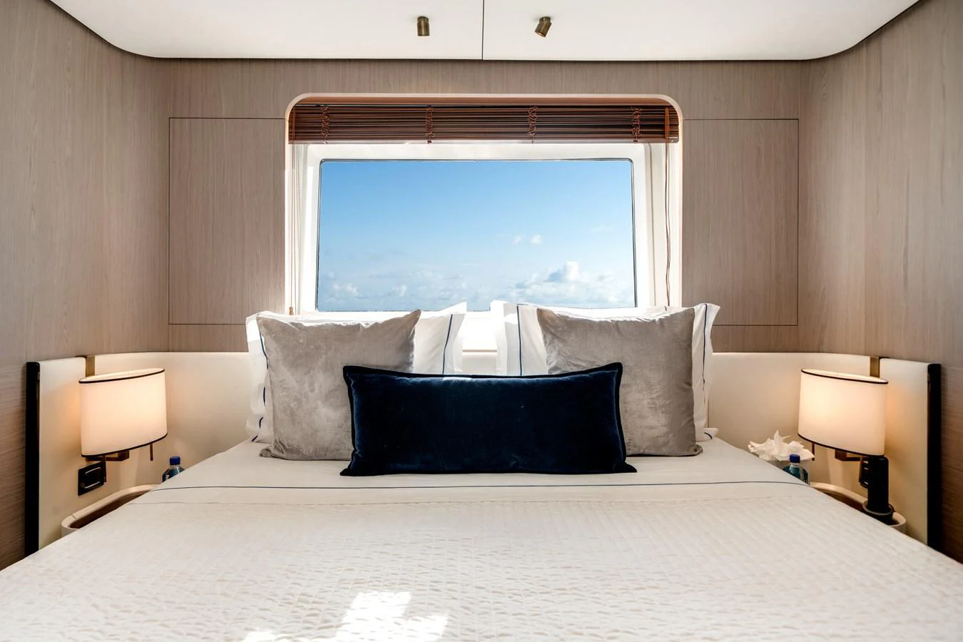 The stateroom features a large bed with plush pillows and a scenic window view. aboard PIER PRESSURE Yacht for Sale