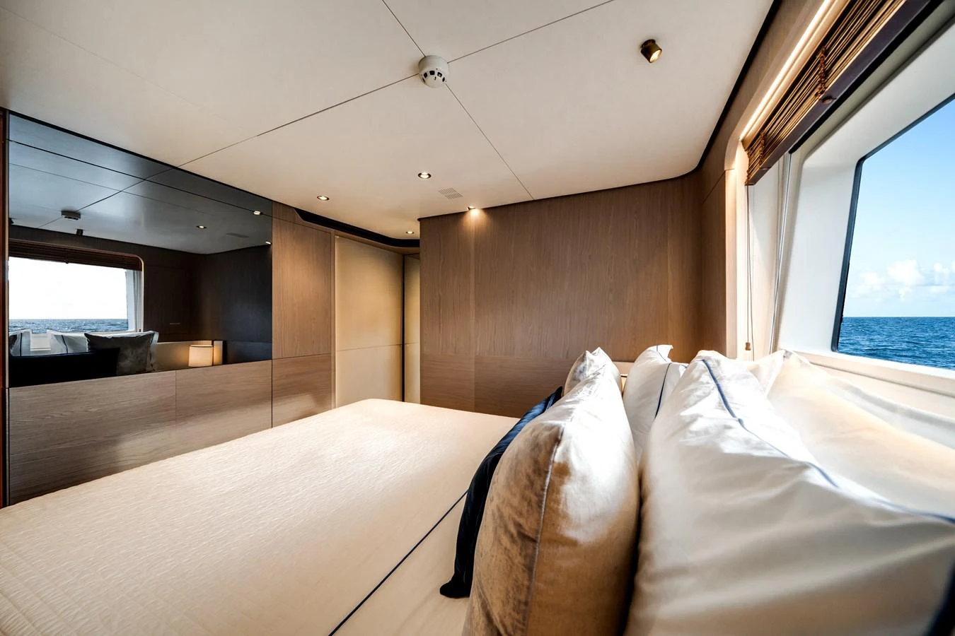 A luxurious stateroom with a large bed and a scenic ocean view through the window. aboard PIER PRESSURE Yacht for Sale