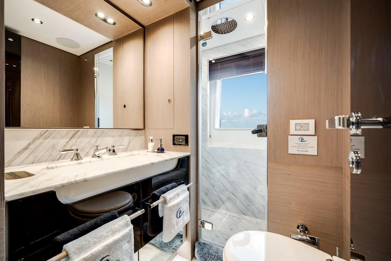 The yacht's bathroom features a sleek design with a double sink and a spacious shower area. aboard PIER PRESSURE Yacht for Sale