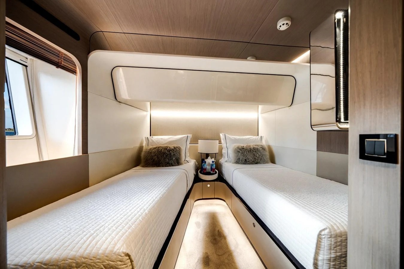 The twin stateroom offers a cozy and modern sleeping area with two single beds and soft lighting. aboard PIER PRESSURE Yacht for Sale