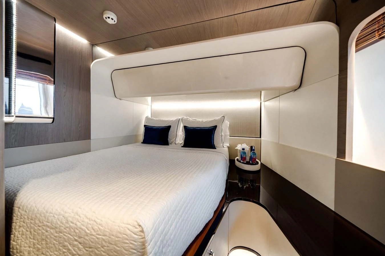 A luxurious stateroom featuring a comfortable bed with plush pillows and modern lighting. aboard PIER PRESSURE Yacht for Sale