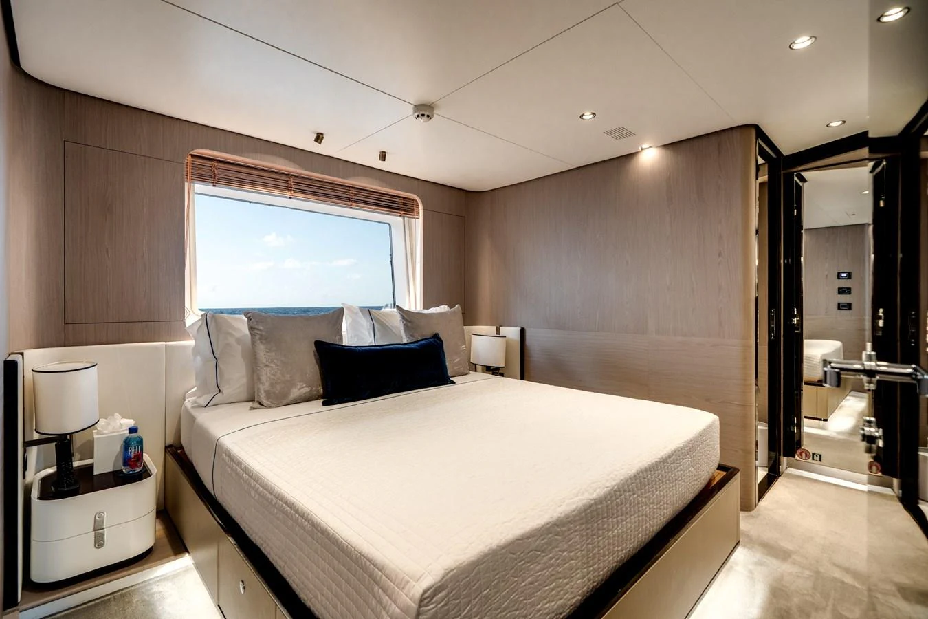The stateroom features a luxurious bed with elegant bedding and a large window offering a stunning sea view. aboard PIER PRESSURE Yacht for Sale
