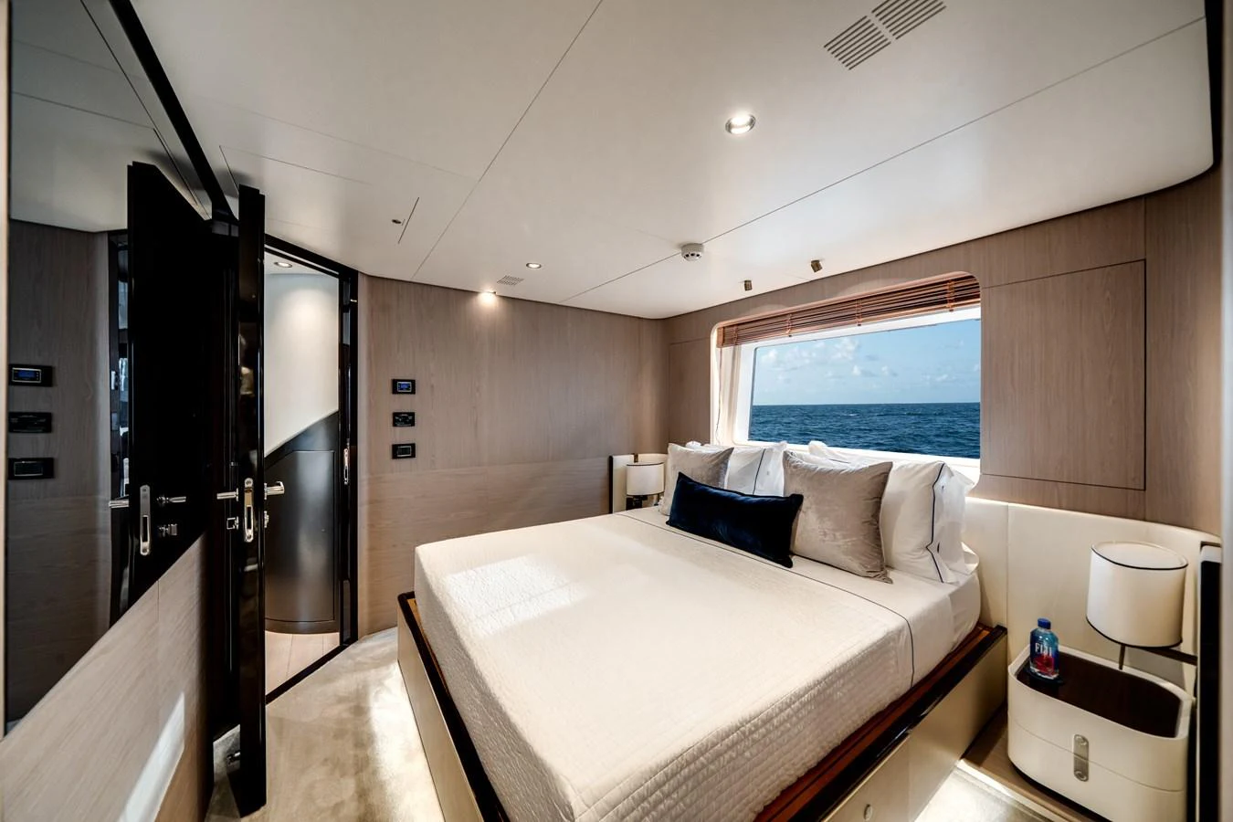 A luxurious stateroom with a large bed and ocean view through the window. aboard PIER PRESSURE Yacht for Sale