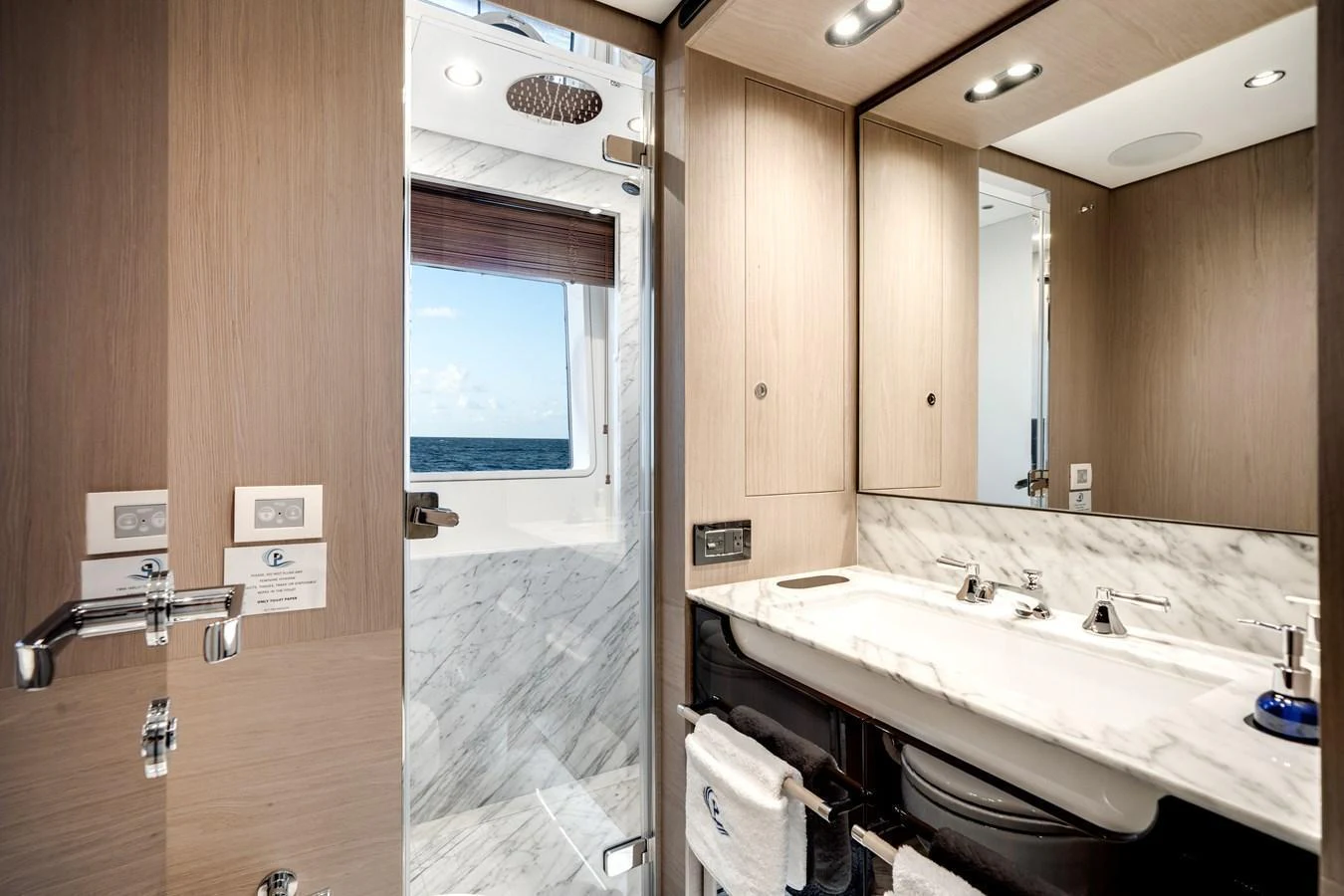 The yacht's bathroom features modern fixtures and a sleek design with a view of the sea. aboard PIER PRESSURE Yacht for Sale