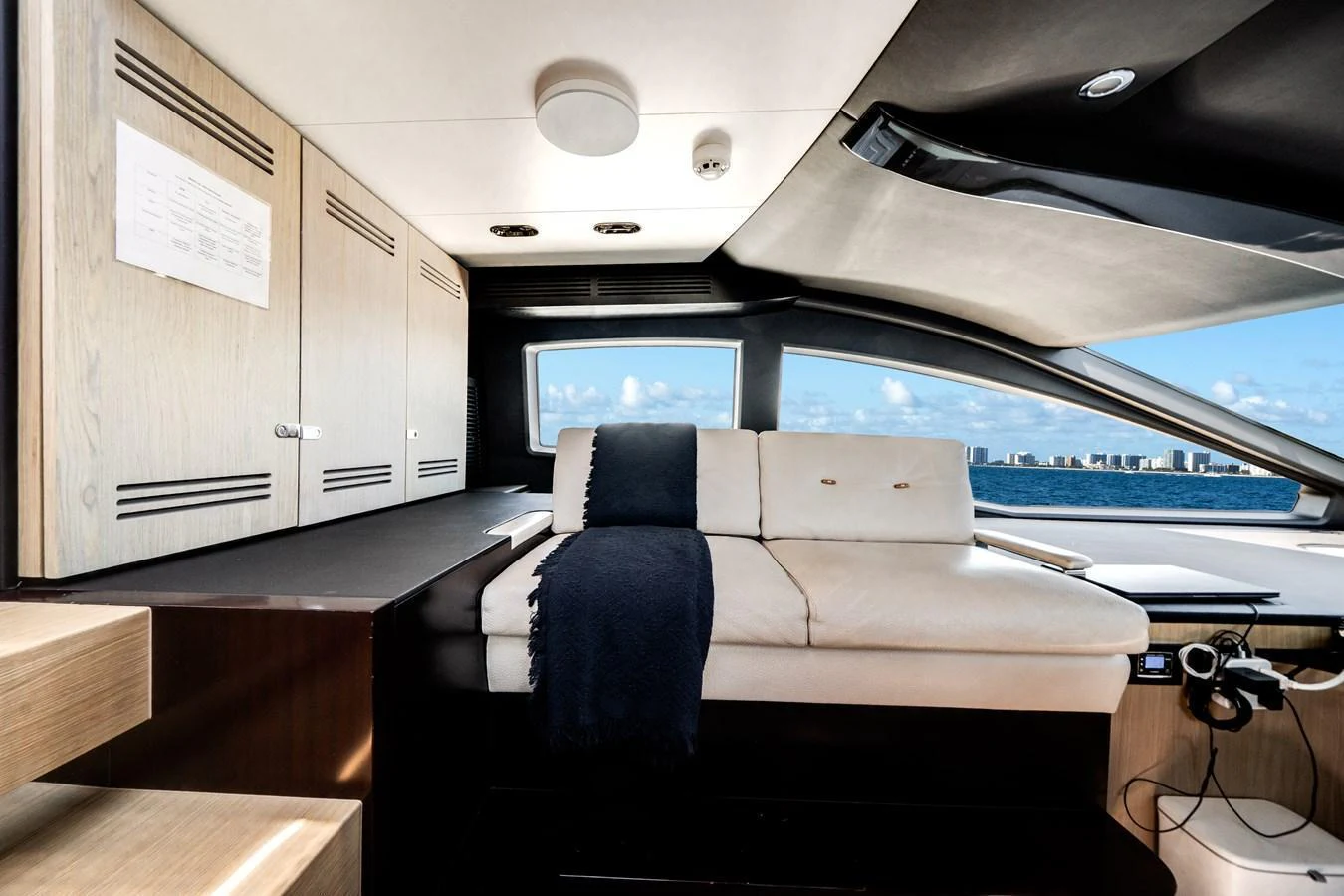 The yacht's interior features a comfortable seating area with a view of the ocean through large windows. aboard PIER PRESSURE Yacht for Sale