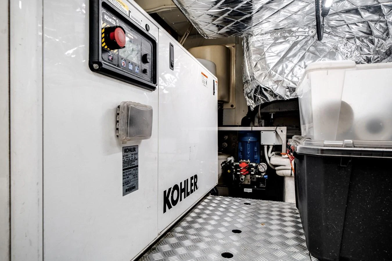 The image showcases the yacht's well-maintained engine room with a Kohler generator. aboard PIER PRESSURE Yacht for Sale