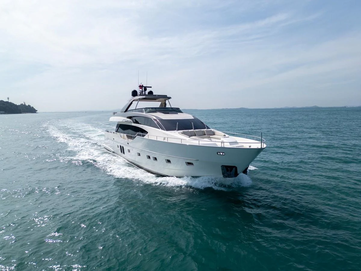 A sleek and modern yacht cruising through calm waters under a clear sky. aboard TNT LEISURE Yacht for Sale