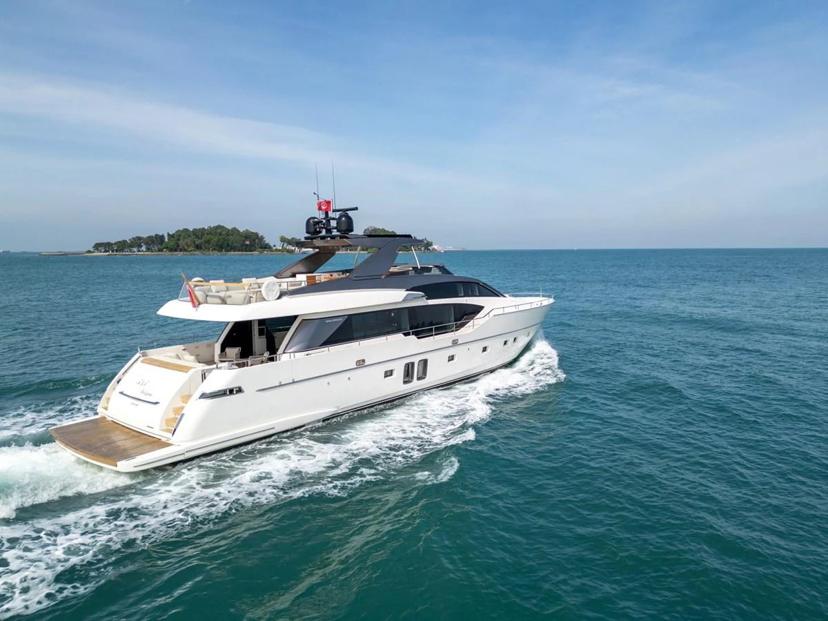 A sleek and modern yacht cruising on calm blue waters under a clear sky. aboard TNT LEISURE Yacht for Sale