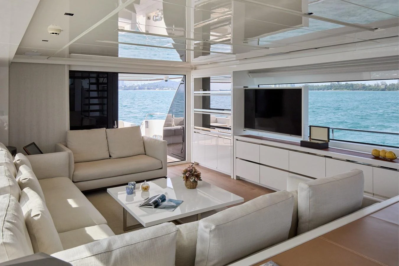 The yacht's salon features plush seating, a large TV, and expansive windows offering stunning ocean views. aboard TNT LEISURE Yacht for Sale