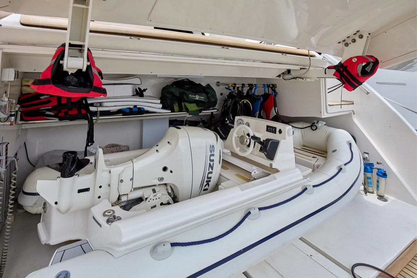 The yacht features a well-equipped storage area for a tender with a Suzuki outboard motor. aboard TNT LEISURE Yacht for Sale