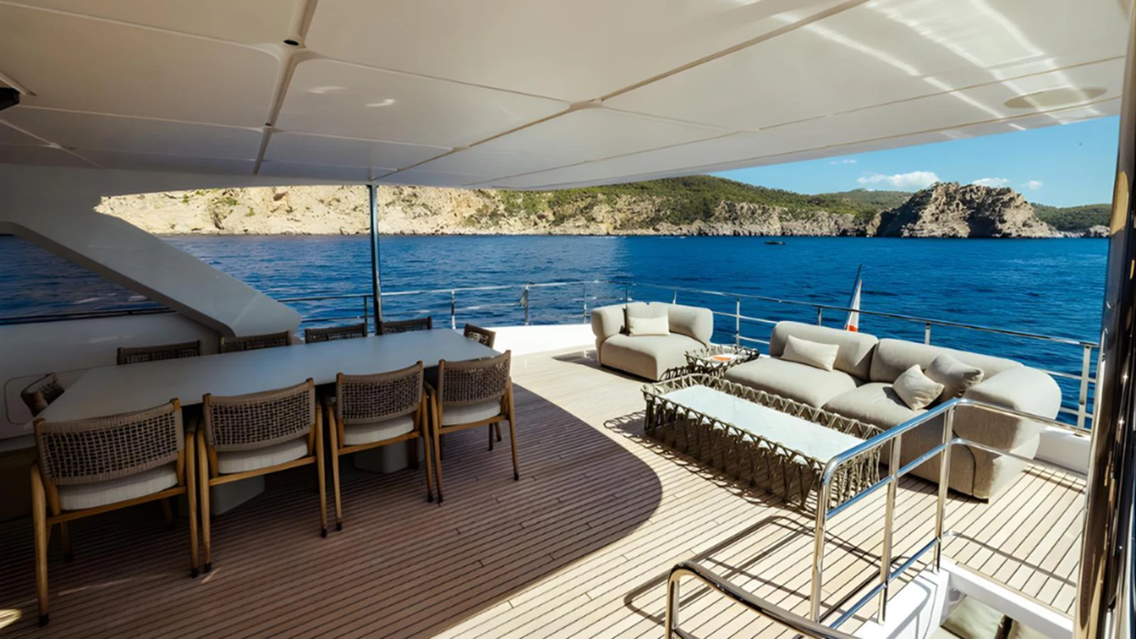 The aft deck offers a spacious and inviting area with comfortable seating and a large dining table, perfect for alfresco dining and relaxation. aboard MARCH SUNRISE Yacht for Sale
