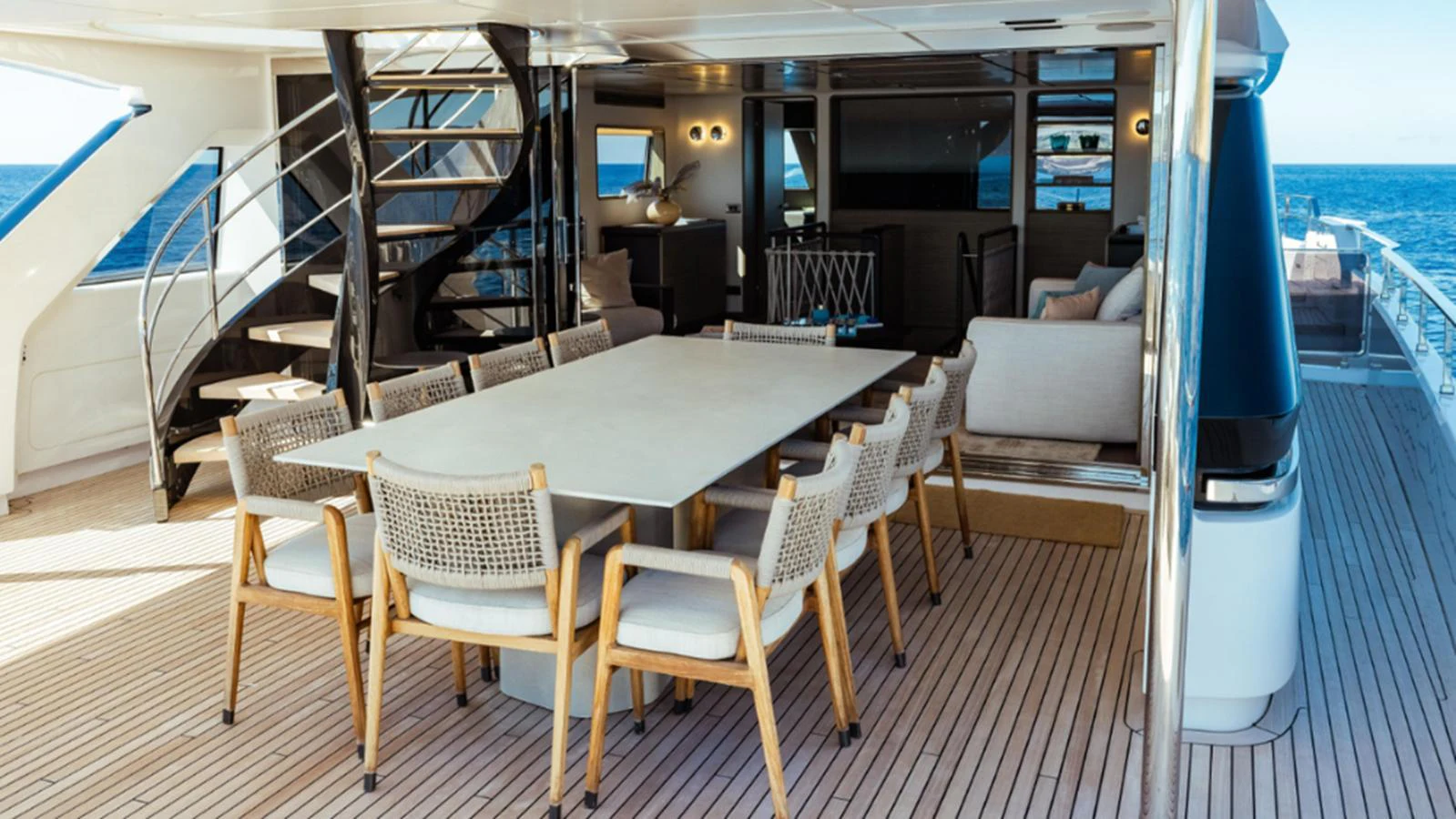 The aft deck features a spacious dining area with a large table and comfortable seating, perfect for alfresco meals with a view of the sea. aboard MARCH SUNRISE Yacht for Sale