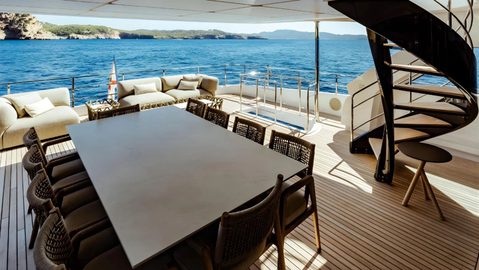 The aft deck features a spacious dining area with a large table and comfortable seating, complemented by a stunning ocean view. aboard MARCH SUNRISE Yacht for Sale