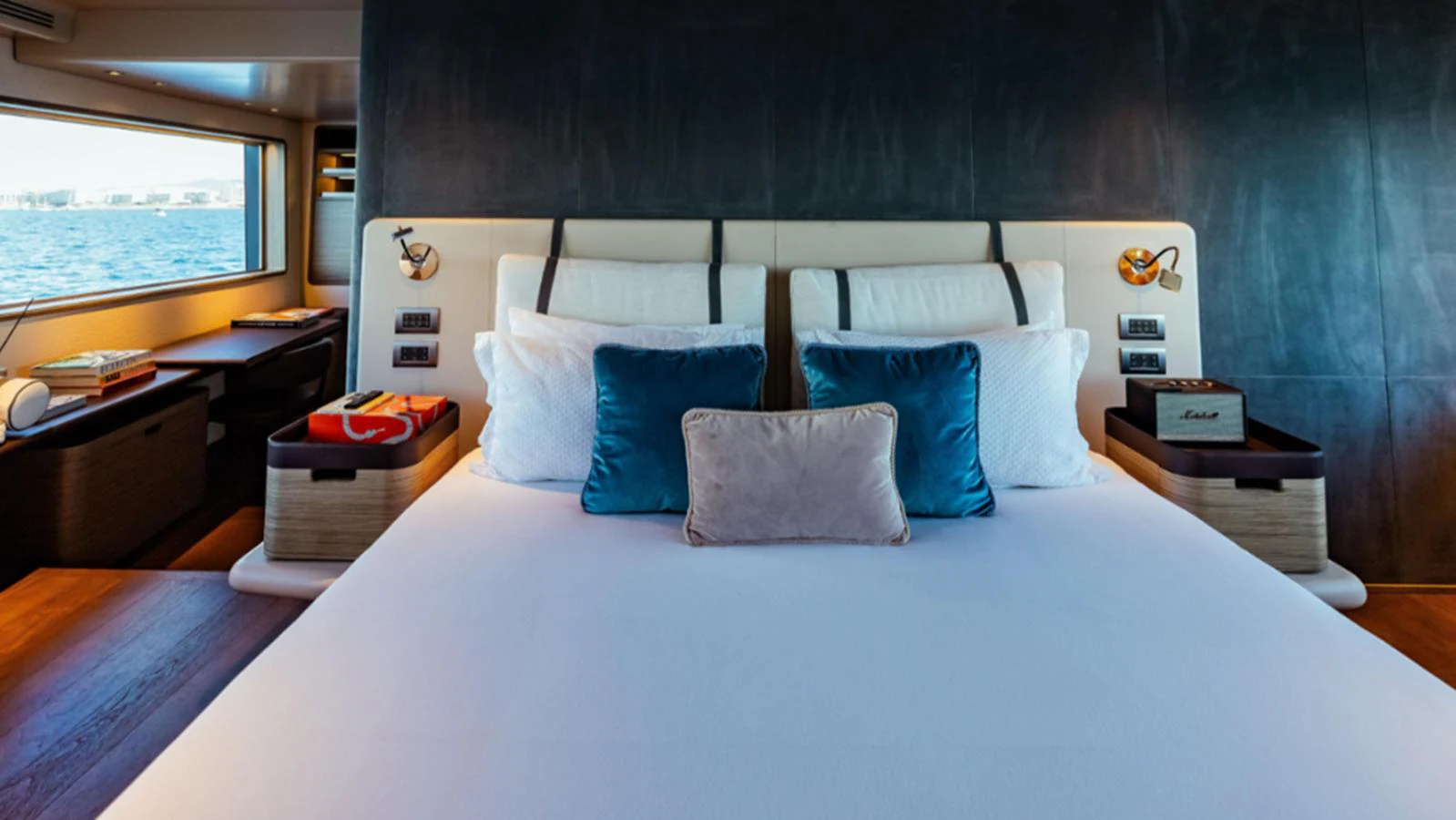 The stateroom features a luxurious bed with plush pillows and a view of the sea through the window. aboard MARCH SUNRISE Yacht for Sale