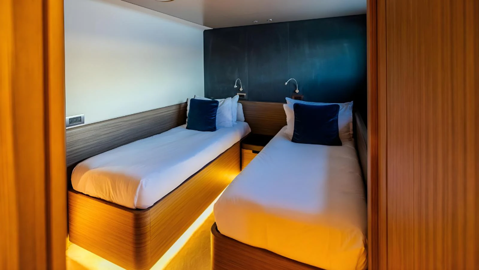 A cozy twin stateroom with modern wooden finishes and ambient lighting. aboard MARCH SUNRISE Yacht for Sale