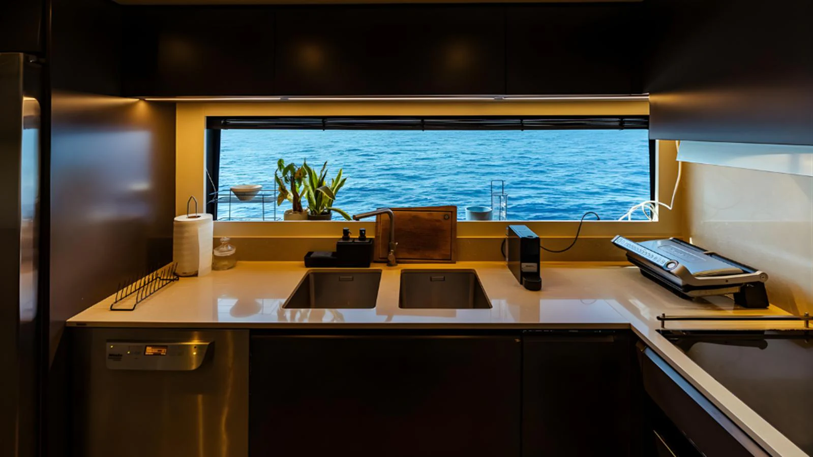The yacht's galley features modern appliances and a stunning ocean view through a large window. aboard MARCH SUNRISE Yacht for Sale