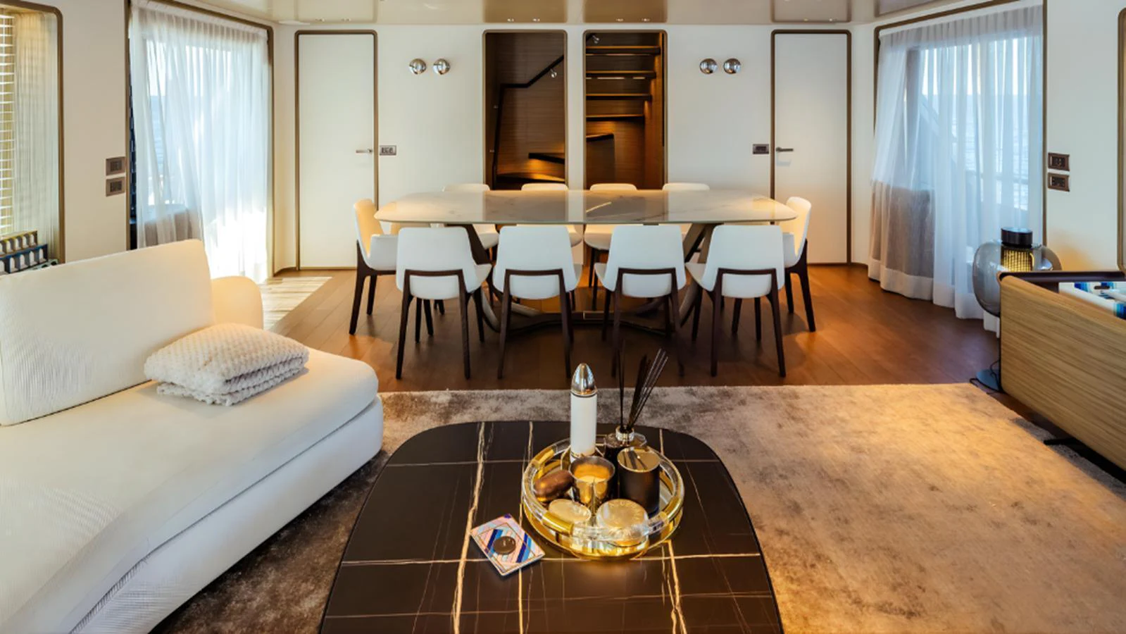 The salon features a spacious seating area with a dining table and modern decor. aboard MARCH SUNRISE Yacht for Sale
