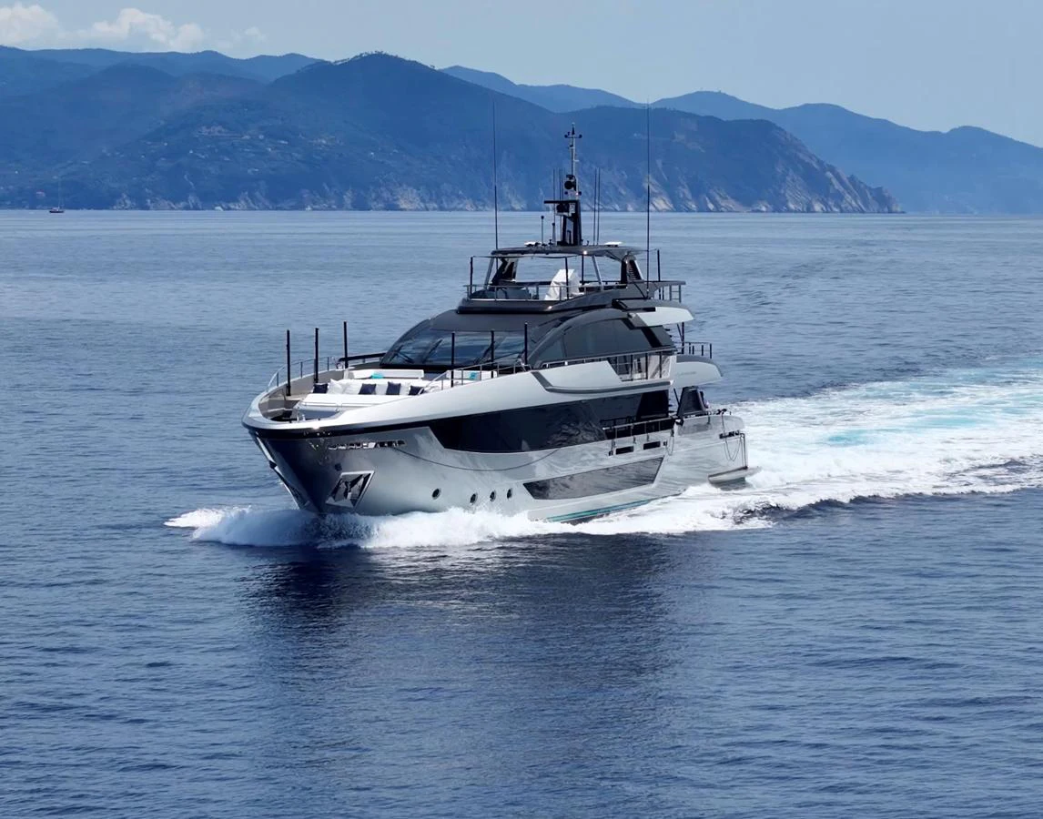 A sleek and modern yacht cruising through calm waters with a scenic mountainous backdrop. aboard ´LANTE Yacht for Sale