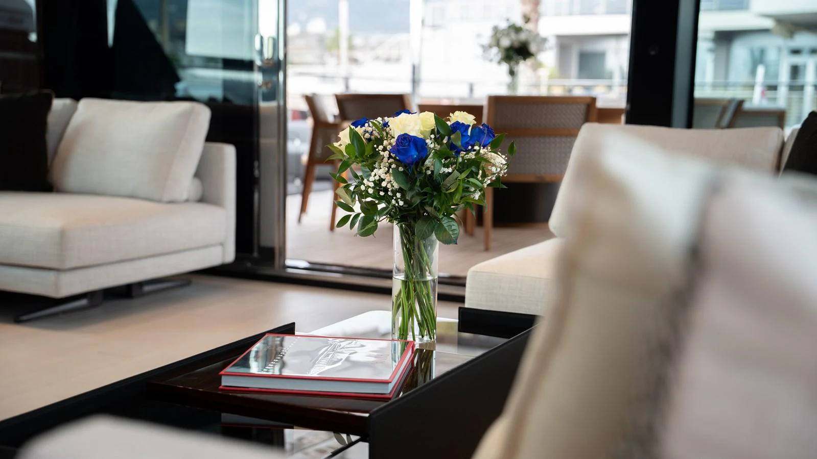 A luxurious yacht interior featuring elegant seating and a beautiful floral arrangement on a coffee table. aboard ´LANTE Yacht for Sale