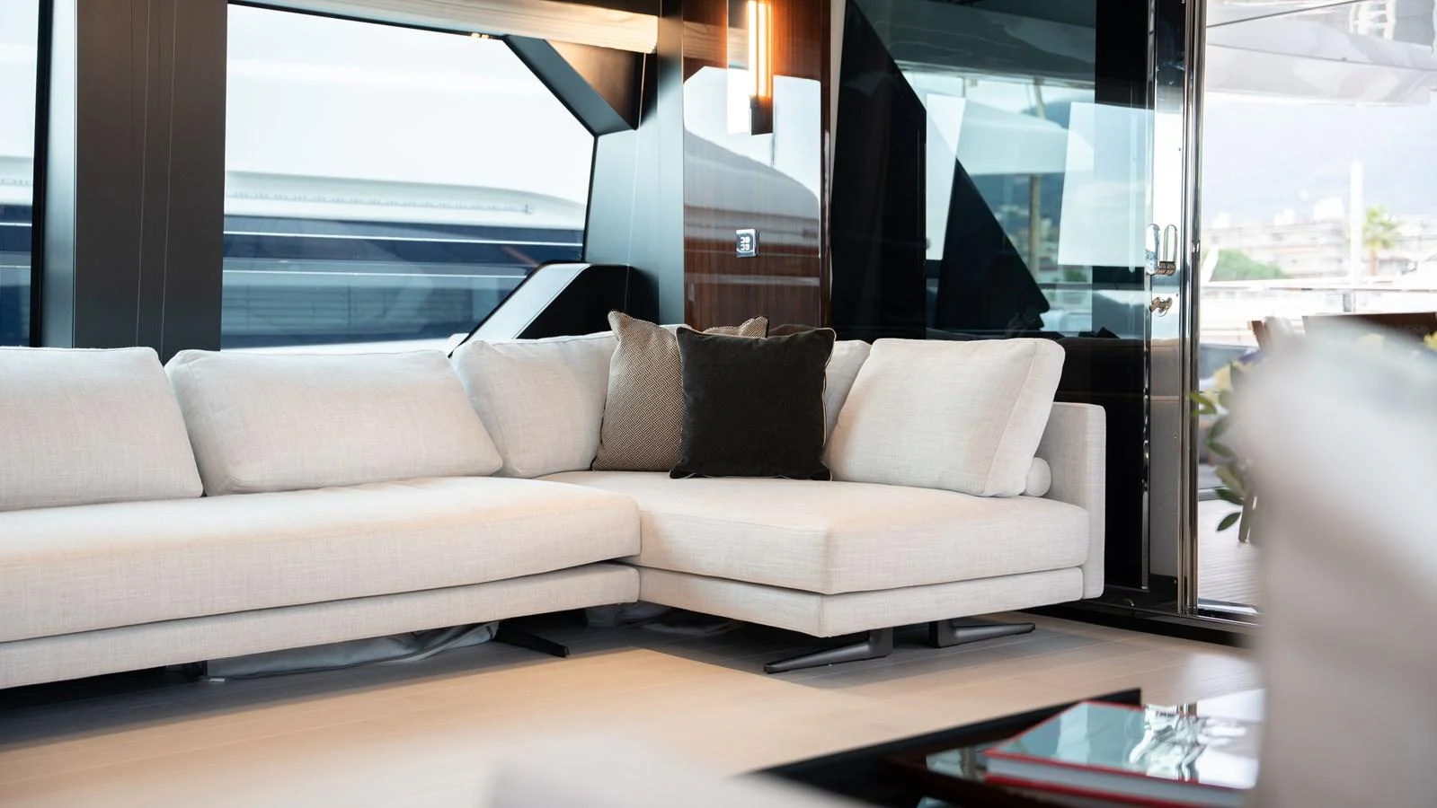The salon features a plush L-shaped sofa with modern decor and ample natural light. aboard ´LANTE Yacht for Sale
