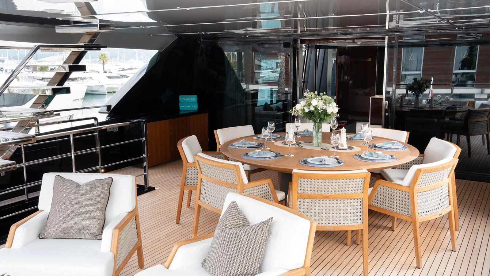 The aft deck features an elegant dining area with a round table and comfortable seating, perfect for alfresco dining. aboard ´LANTE Yacht for Sale