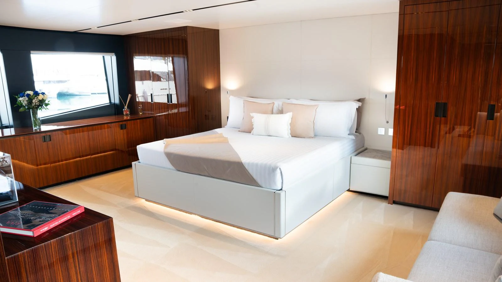 The master stateroom features a luxurious bed with elegant wood paneling and ample natural light. aboard ´LANTE Yacht for Sale