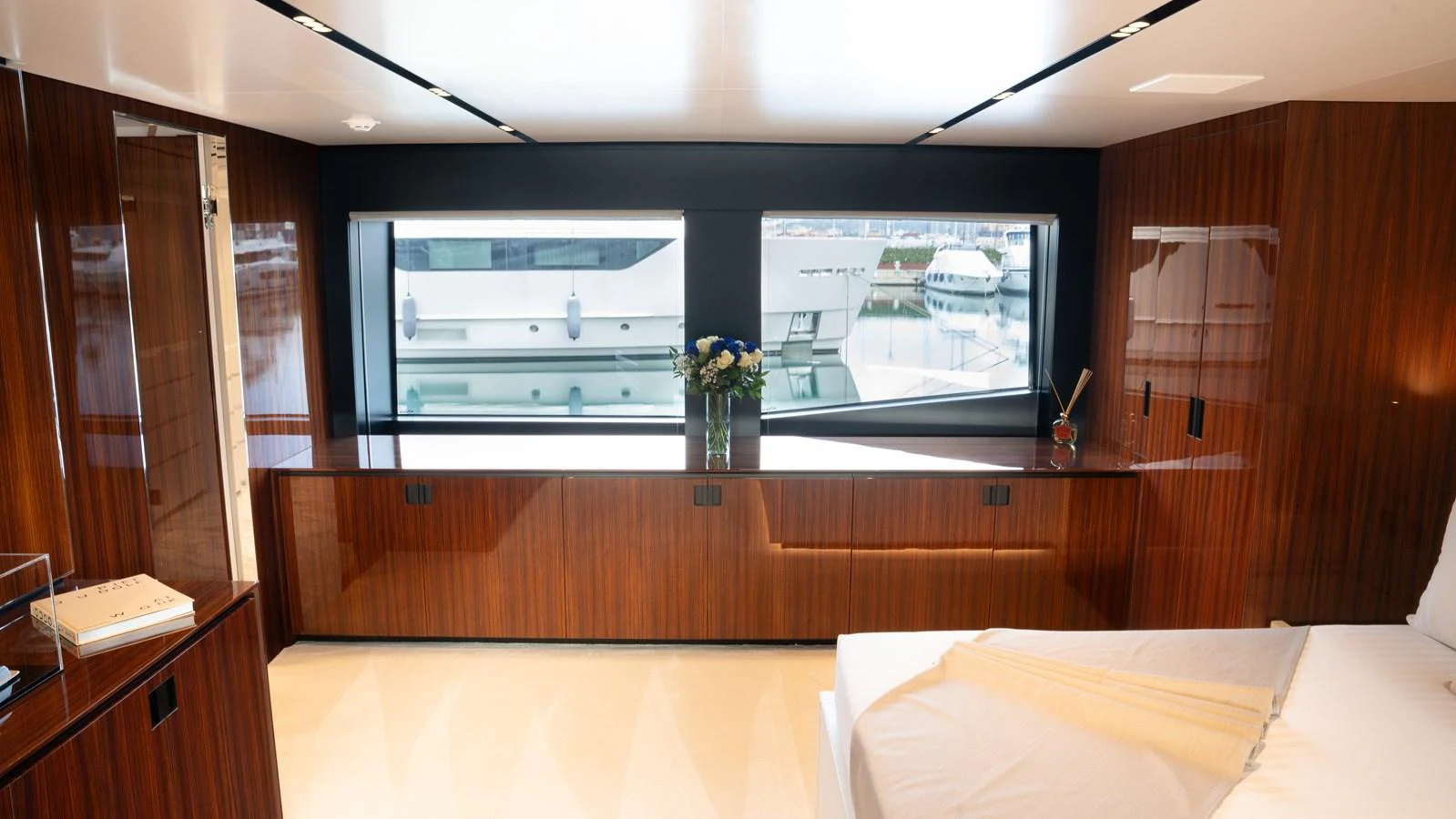 The stateroom features elegant wood paneling and large windows offering a view of the marina. aboard ´LANTE Yacht for Sale