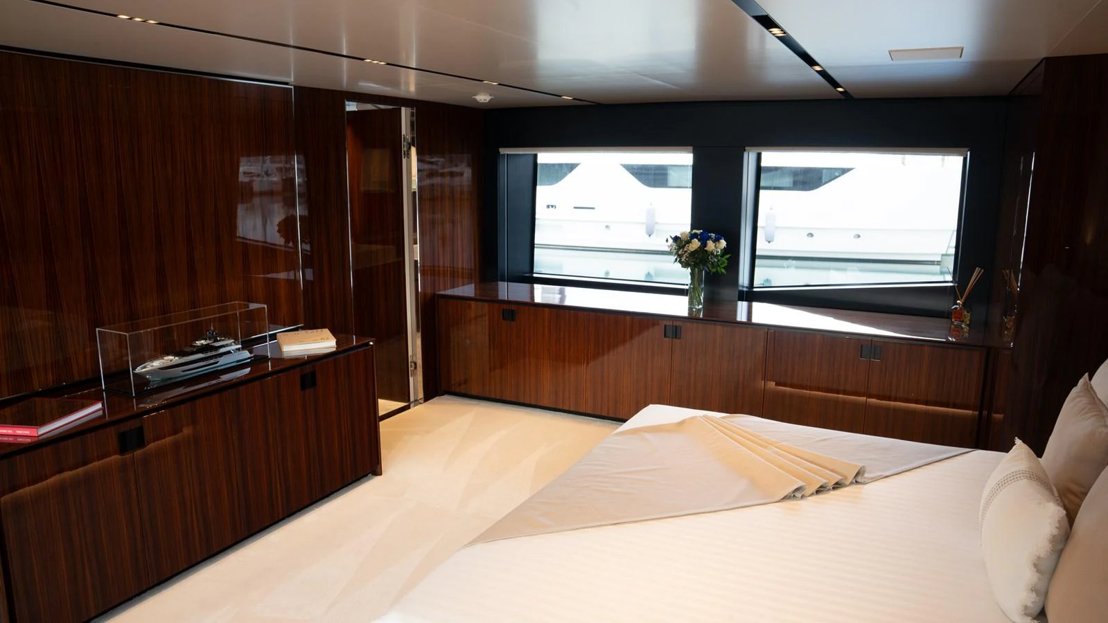 The stateroom features elegant wood paneling, large windows, and a comfortable bed. aboard ´LANTE Yacht for Sale