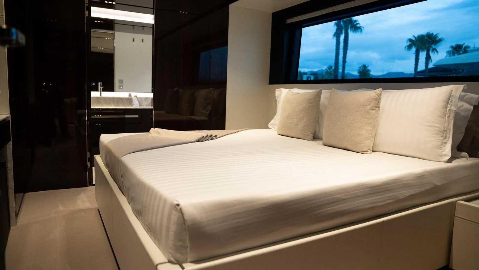 A luxurious stateroom featuring a large bed with plush pillows and a scenic window view. aboard ´LANTE Yacht for Sale