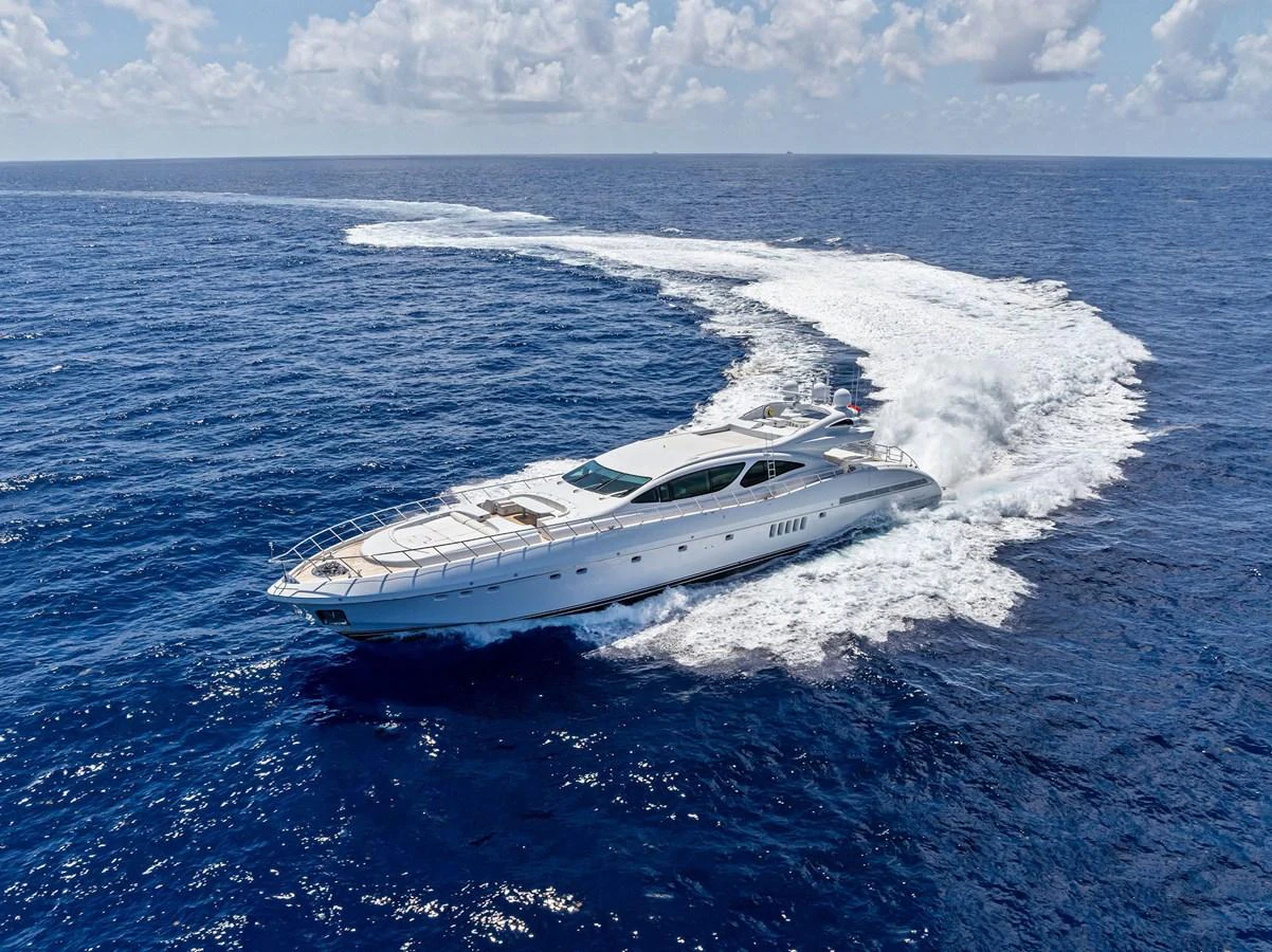 A sleek yacht cruises swiftly through the open ocean, leaving a trail of white wake behind. aboard INCOGNITO Yacht for Sale